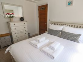 A bedroom with a bed and dresser at Heron in St Ives