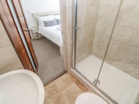 A bathroom with a shower and toilet adjacent to a bedroom at Heron in St Ives