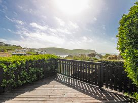 A view from a deck overlooking the sea and hills at Eddystone in Hope Cove