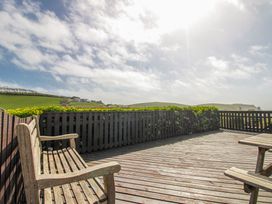 An outdoor area with wooden benches and decking at Eddystone in Hope Cove