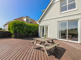 A deck area with wooden furniture at Eddystone in Hope Cove