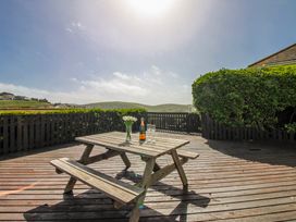 A table with drinks and flowers on a deck at Eddystone in Hope Cove