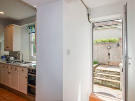 A kitchen with a sink and door leading to steps at Eddystone in Hope Cove