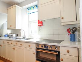 A kitchen with cabinets, sink, and stove at Eddystone in Hope Cove