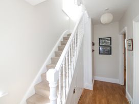 A hallway with stairs and photos on the wall at Eddystone in Hope Cove