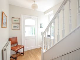 A hallway with a chair and door at Eddystone in Hope Cove