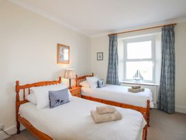 A bedroom with two beds and a lamp at Eddystone in Hope Cove