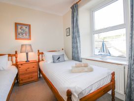 A bedroom with two beds and a lamp at Eddystone in Hope Cove