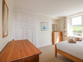 A bedroom with a bed, dresser, and window at Eddystone in Hope Cove