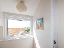 A hallway with a window, light fixture, and painting at Eddystone, Hope Cove