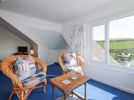 A living room with wicker chairs and a table at Eddystone in Hope Cove