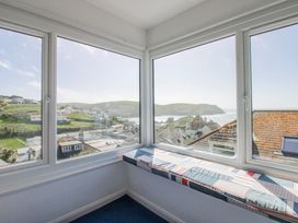 A sunroom with a window seat and views of the ocean at Eddystone Hope Cove