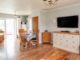 A dining room with a table and chairs at Bro Mebyd in Criccieth