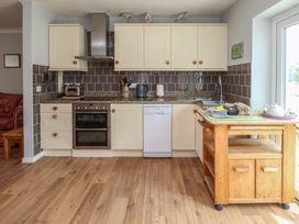 A kitchen with cabinets and appliances at Bro Mebyd in Criccieth