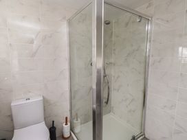 A bathroom with a shower and toilet at Bro Mebyd Criccieth