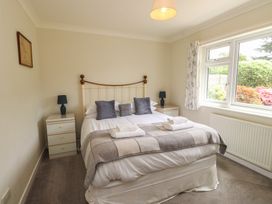 A bedroom with a bed and nightstands at Bro Mebyd in Criccieth