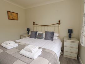 A bedroom with a bed and bedside tables at Bro Mebyd in Criccieth