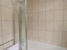 A bathroom with a shower and bathtub at Bro Mebyd in Criccieth
