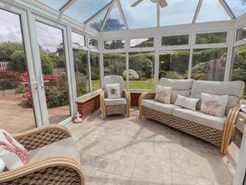A conservatory with seating area at Bro Mebyd in Criccieth