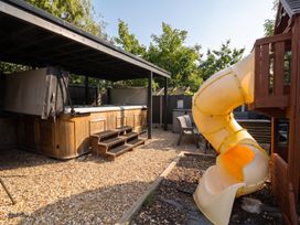 An outdoor area with a hot tub, slide, and seating at Cabin Hill in Rhos-On-Sea