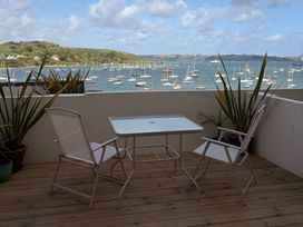 A balcony with a table and chairs overlooking the sea at 58 High Street in Falmouth