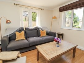 A living room with a sofa and wooden table at White Stones in Fulbrook, near Burford