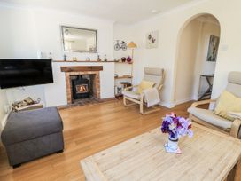 A living room with a fireplace and seating area at White Stones in Fulbrook, near Burford