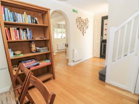 A hallway with a bookshelf and chair at White Stones Fulbrook, near Burford