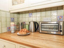 A kitchen with a kettle cups croissants and toaster oven at White Stones in Fulbrook, near Burford
