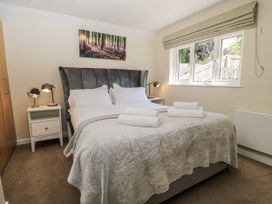 A bedroom with a double bed and a bedside table at White Stones, Fulbrook, near Burford