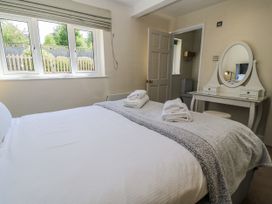 A bedroom with a bed and dressing table at White Stones in Fulbrook, near Burford