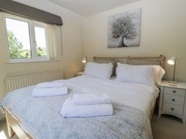 A bedroom with a bed and bedside table at White Stones in Fulbrook, near Burford