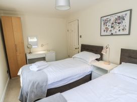 A bedroom with twin beds, a desk, and a wardrobe at White Stones Fulbrook, near Burford