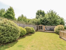 A garden with a shed and chairs at White Stones, Fulbrook, near Burford