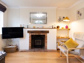 A living room with a fireplace and television at White Stones in Fulbrook, near Burford