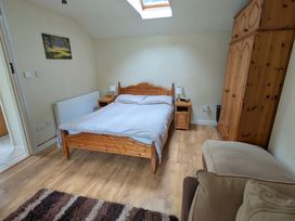 A bedroom with a bed and wardrobe at Little Pandy Cottage Afonwen near Caerwys