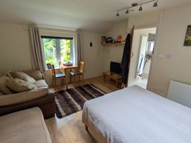 A studio apartment with a sofa and a dining area at Little Pandy Cottage Afonwen near Caerwys
