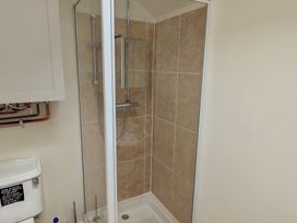 A shower enclosure and toilet in a bathroom at Little Pandy Cottage Afonwen near Caerwys