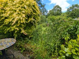 A garden with a table and various plants at Little Pandy Cottage Afonwen near Caerwys