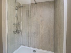 A shower enclosure with a glass door and tiled walls at 4 Duck Street Dorchester