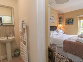 A bathroom with a sink and mirror adjacent to a bedroom with a bed at 4 Duck Street in Dorchester