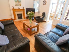 A living room with a fireplace and television at Cherry Tree House in Penzance