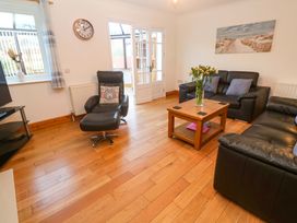 A living room with a clock and a coffee table at Cherry Tree House in Penzance