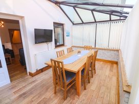 A conservatory with a dining table and chairs at Cherry Tree House in Penzance