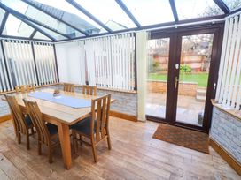 A conservatory with a table and chairs at Cherry Tree House in Penzance