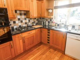 A kitchen with cabinets and a gas stove at Cherry Tree House in Penzance