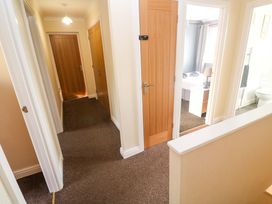 A hallway with doors leading to a bathroom and a bedroom at Cherry Tree House Penzance