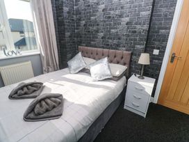 A bedroom with a bed and bedside table at Cherry Tree House in Penzance
