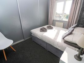 A bedroom with a bed and chair at Cherry Tree House in Penzance