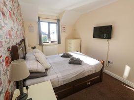 A bedroom with a bed and television at Cherry Tree House in Penzance
